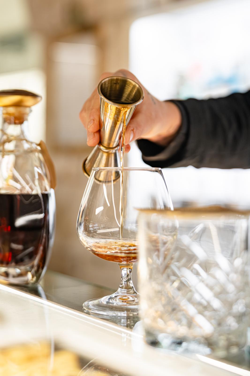 Versamento di distillato in un bicchiere brandy